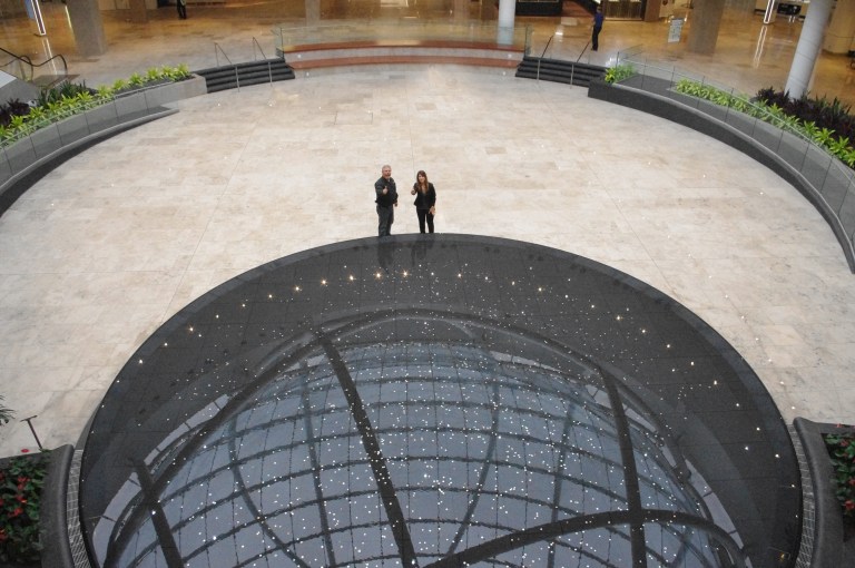 Eden Food For Change executive director Bill Crawford and Erin Mills Town Centre marketing director Francesca Bourré toss coins into the mall's new infinity fountain. Coins collected are going to benefit EFFC over the next year. (Photo: Eden Food for Change)